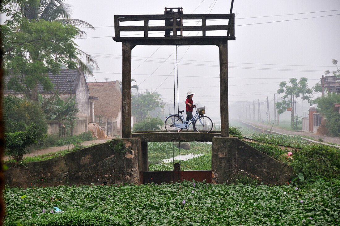 Frau mit Fahrrad, Landschaft in der Trockenen Halong Bucht bei Ninh Binh, Nord-Vietnam, Vietnam