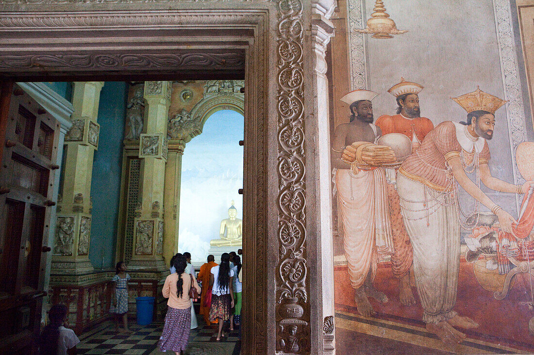 Buddhists in front of Buddha statue and mural paintings from the 18 Century inside the Kelaniya Raja Maha Vihara temple, Colombo, Sri Lanka, Asia