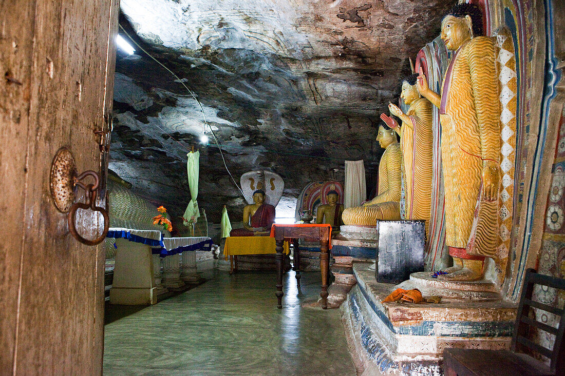 Mural paintings and Buddha statues inside of the cave monastery Rasvehera, Sri Lanka, Asia