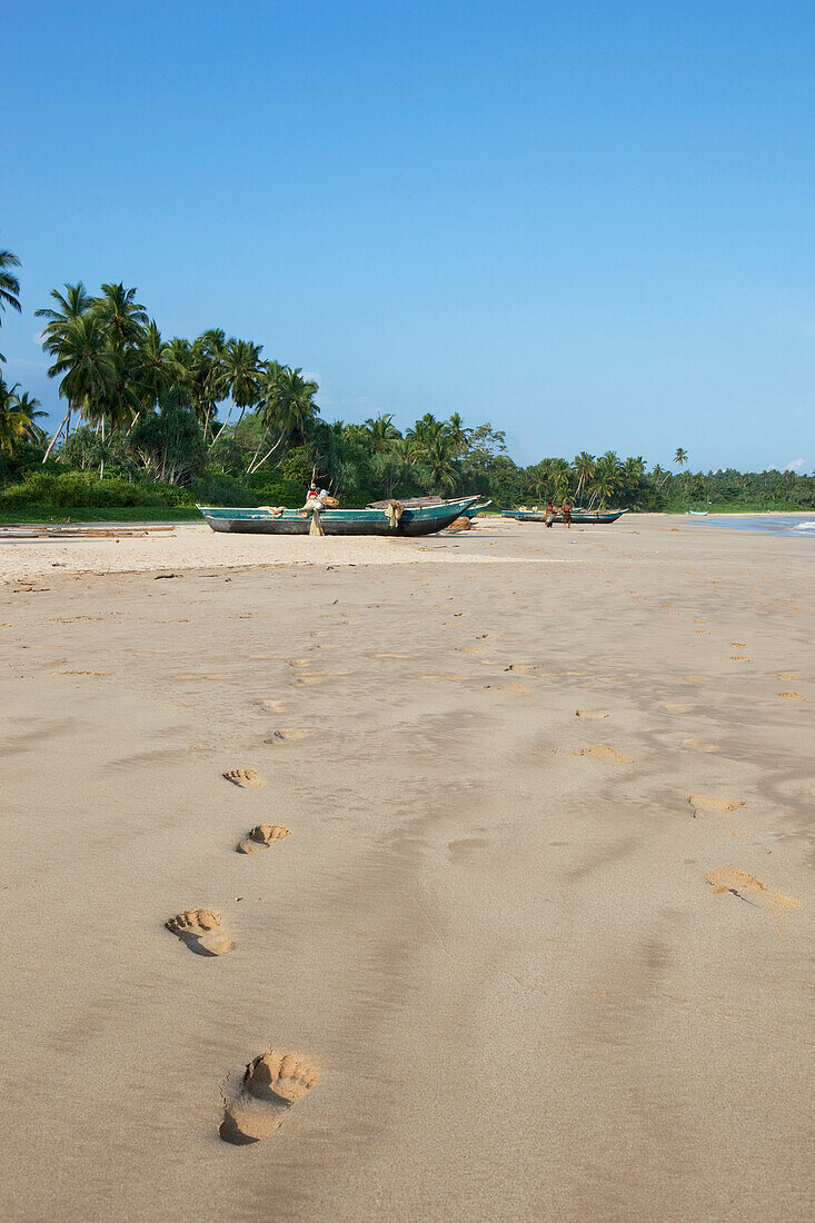 Footprints in the sand leading to the fishing boats at Talalla beach, Talalla, Matara, South coast, Sri Lanka, Asia