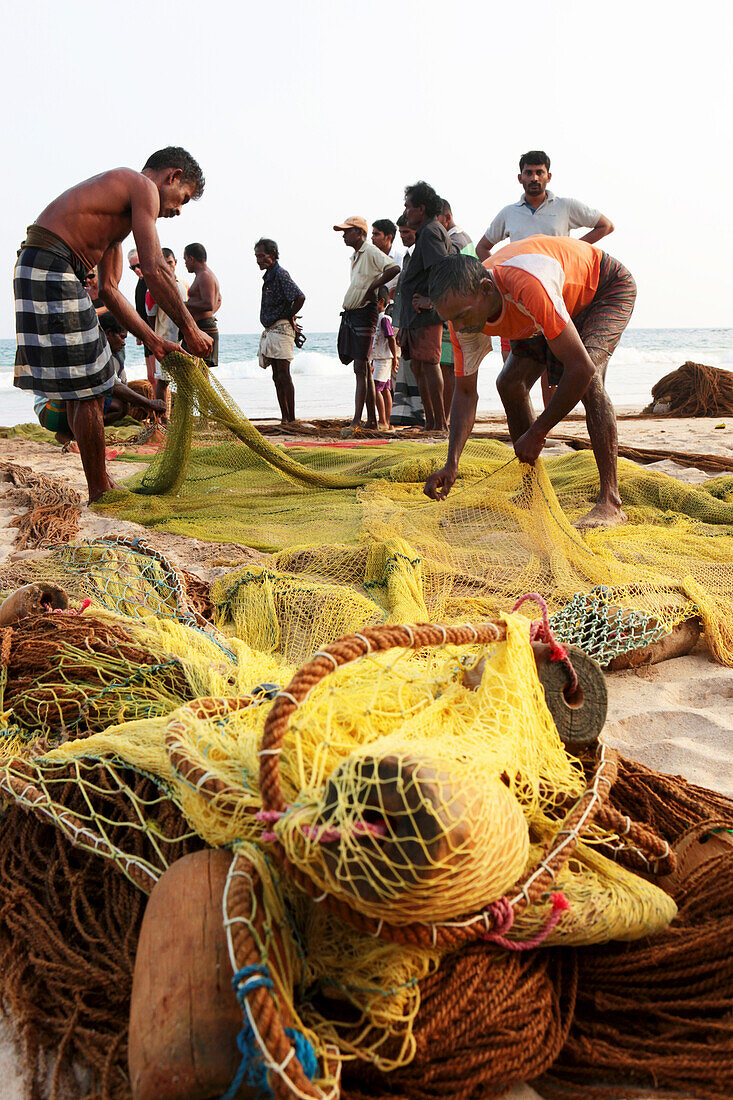 Sinhalese fishermen at Talalla beach pulling in their fishing net, Talalla, Matara, South coast, Sri Lanka, Asia