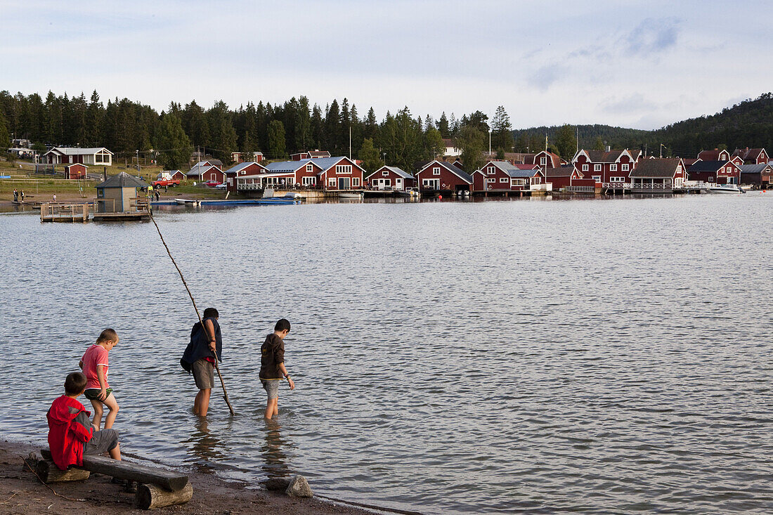 Buben spielen im Wasser vor dem Dorf Norrfällsviken, Höga Kusten, Västernorrland, Schweden, Europa