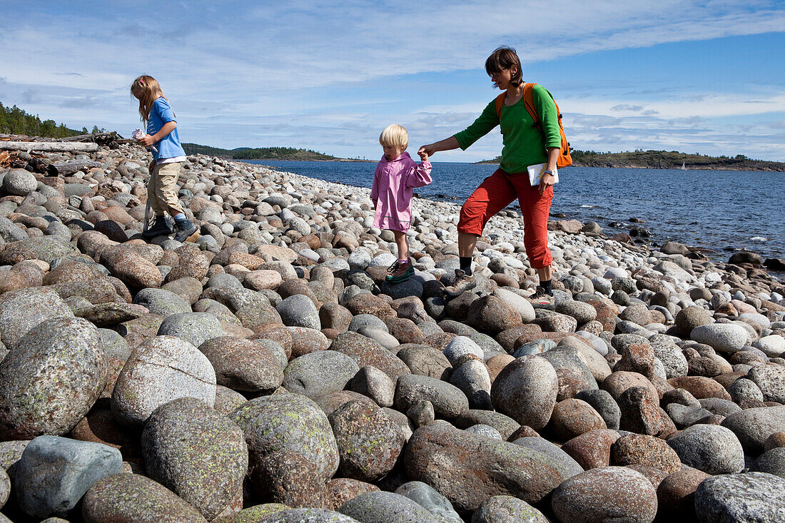 Eine Frau und zwei Mädchen wandern im Naturschutzgebiet Rotsidan, Höga Kusten, Västernorrland, Schweden., Europa