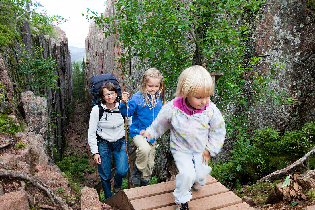 Frau und zwei Mädchen wandern in der Schlucht Slattdalsskrevan im Nationalpark Skuleskogen, Höga Kusten, Västernorrland, Schweden, Europa