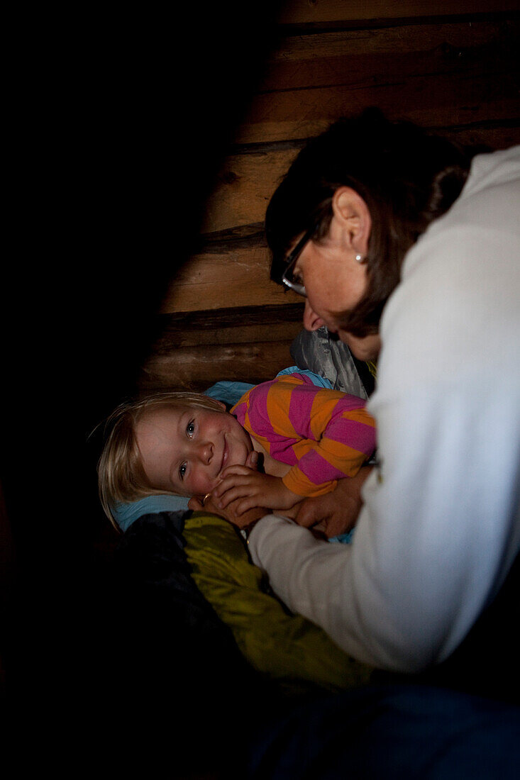Mother saying good night to a girl in a cottage, national park Skuleskogen, Höga Kusten, Vaesternorrland, Sweden, Europe