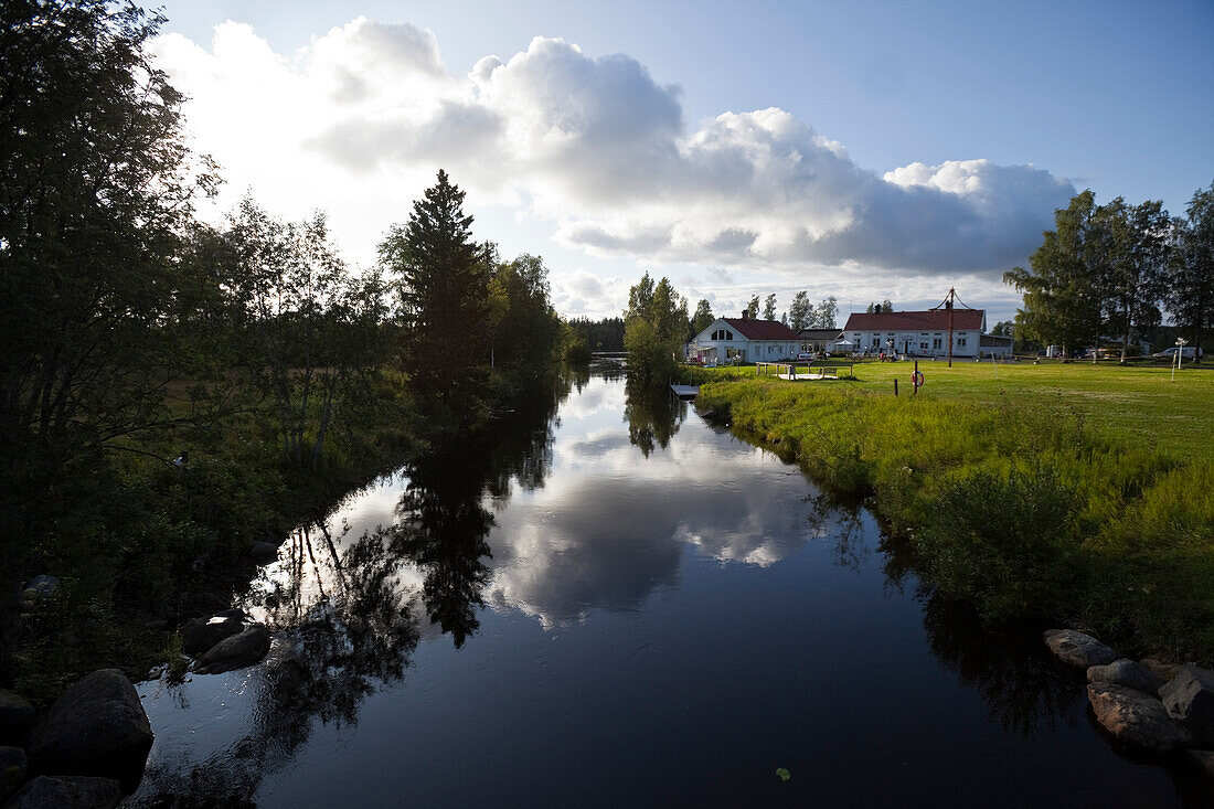 Häuser am Fluss unter Wolkenhimmel, Skeppsviks Herrgard, Västerbotten, Schweden, Europa