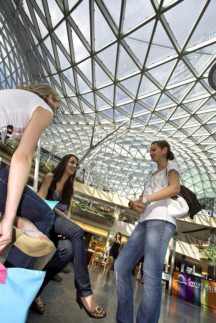 Young Polish women meet for shopping under the glass-roofed Zlote Tarasy shopping Complex, Warsaw, Poland, Europe