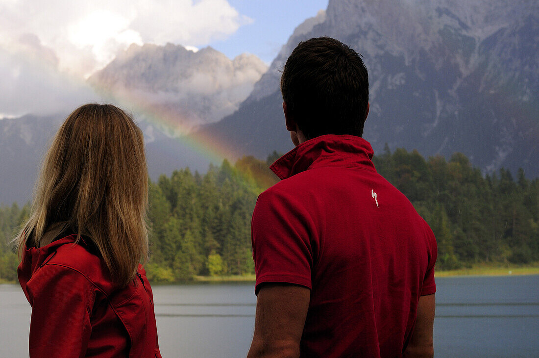 Junges Paar betrachtet Regenbogen, Lautersee, Mittenwald, Werdenfelser Land, Oberbayern, Deutschland