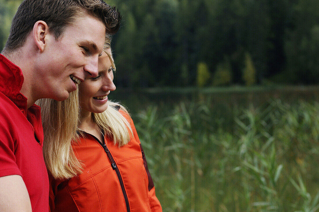 Young couple smiling, lake Lautersee, Mittenwald, Werdenfelser Land, Upper Bavaria, Germany