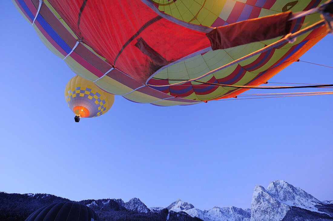 Zwei Heißluftballone fliegen übereinander, Waxensteine im Hintergrund, Garmisch-Partenkirchen, Wetterstein, Bayerische Alpen, Oberbayern, Bayern, Deutschland, Europa