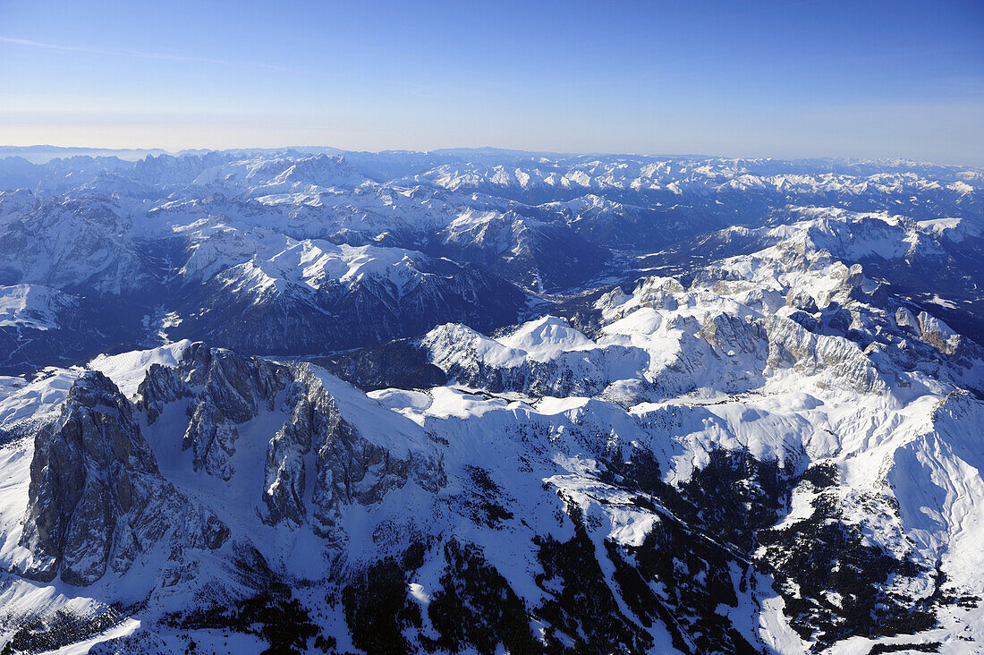 View at Langkofel, Fuenffingerspitze, Plattkofel and Seiseralm in winter, Pala range, Lagorai range and Latemar range in background, aerial photo, Dolomites, South Tyrol, Italy, Europe