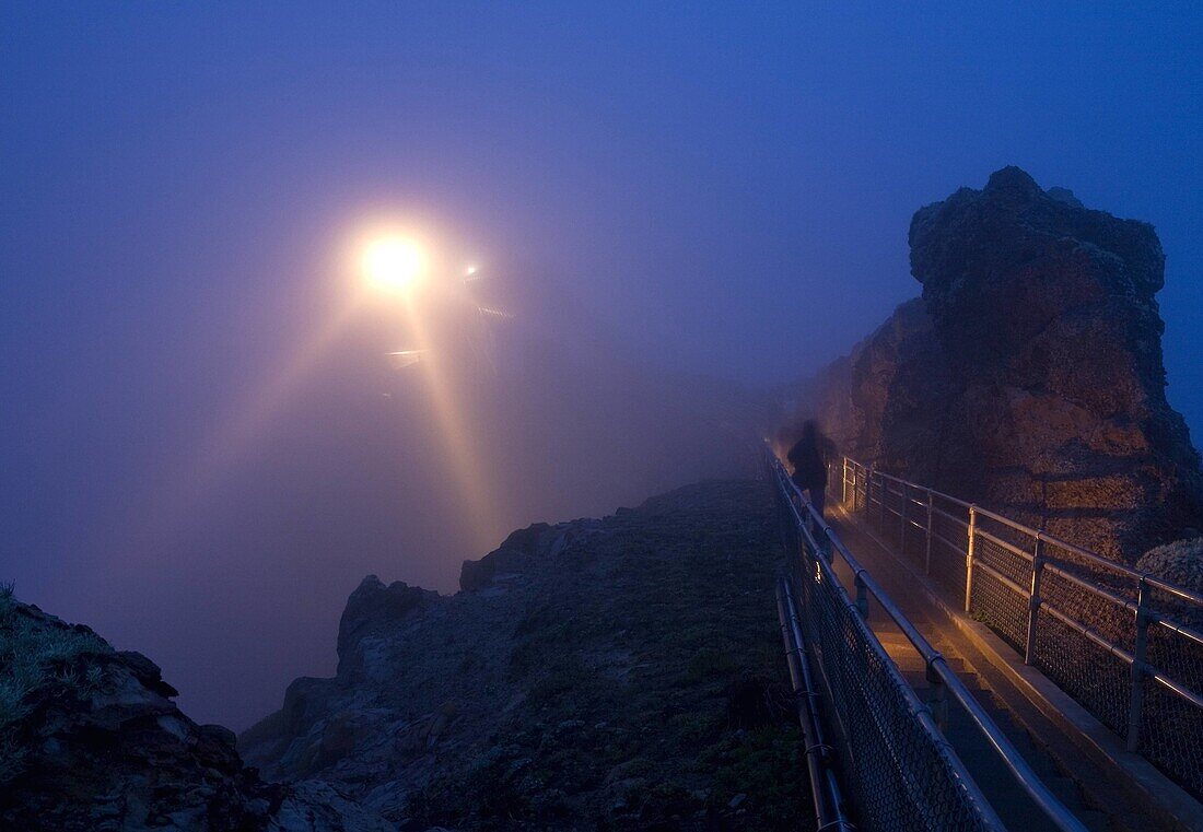 USA, California, Marin County, Point Reyes National Seashore, lighthouse and staircase in fog at dusk, person on stairs