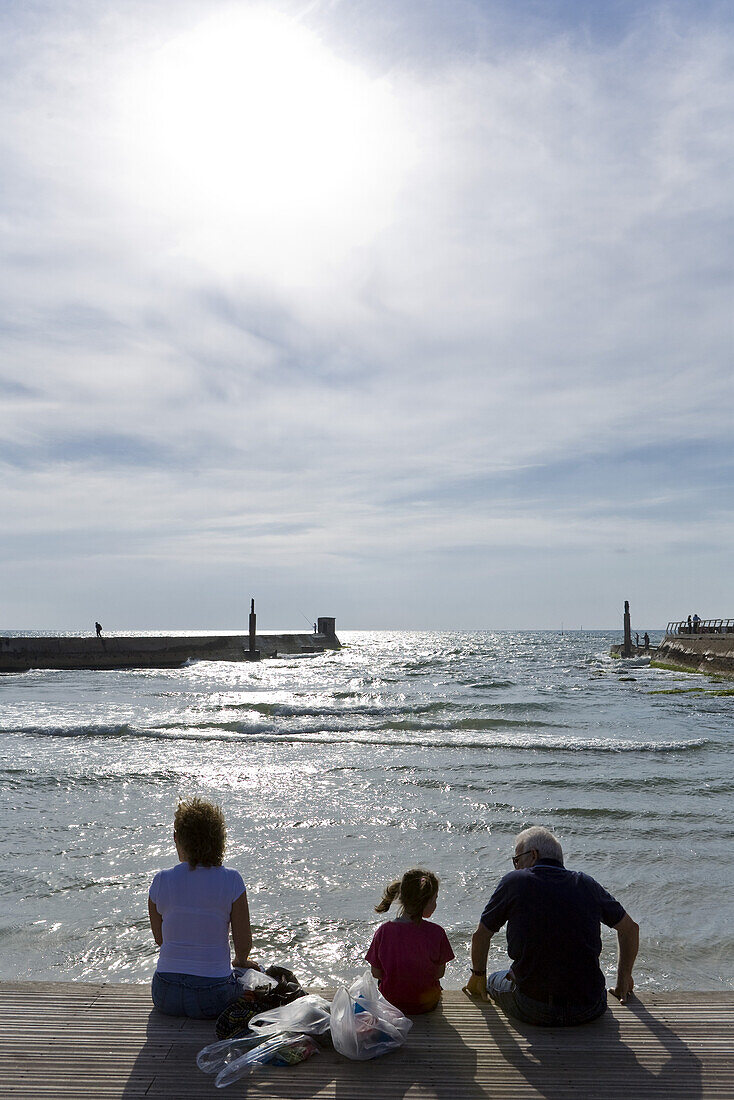 Familie sitzt auf der Strandpromenade in der Sonne, Namal, Tel Aviv, Israel, Naher Osten