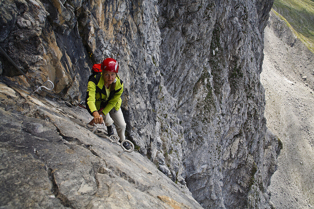 Frau klettert über Senda Ferrata verticala, Piz Mitgel, Savognin, Kanton Graubünden, Schweiz