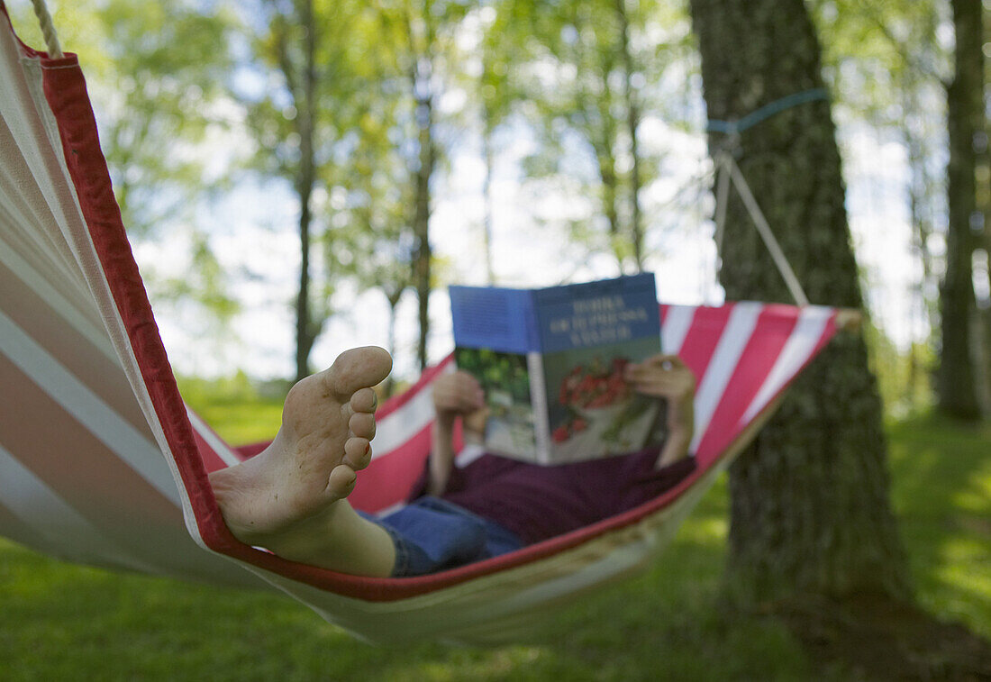 Girl reading book in hammock