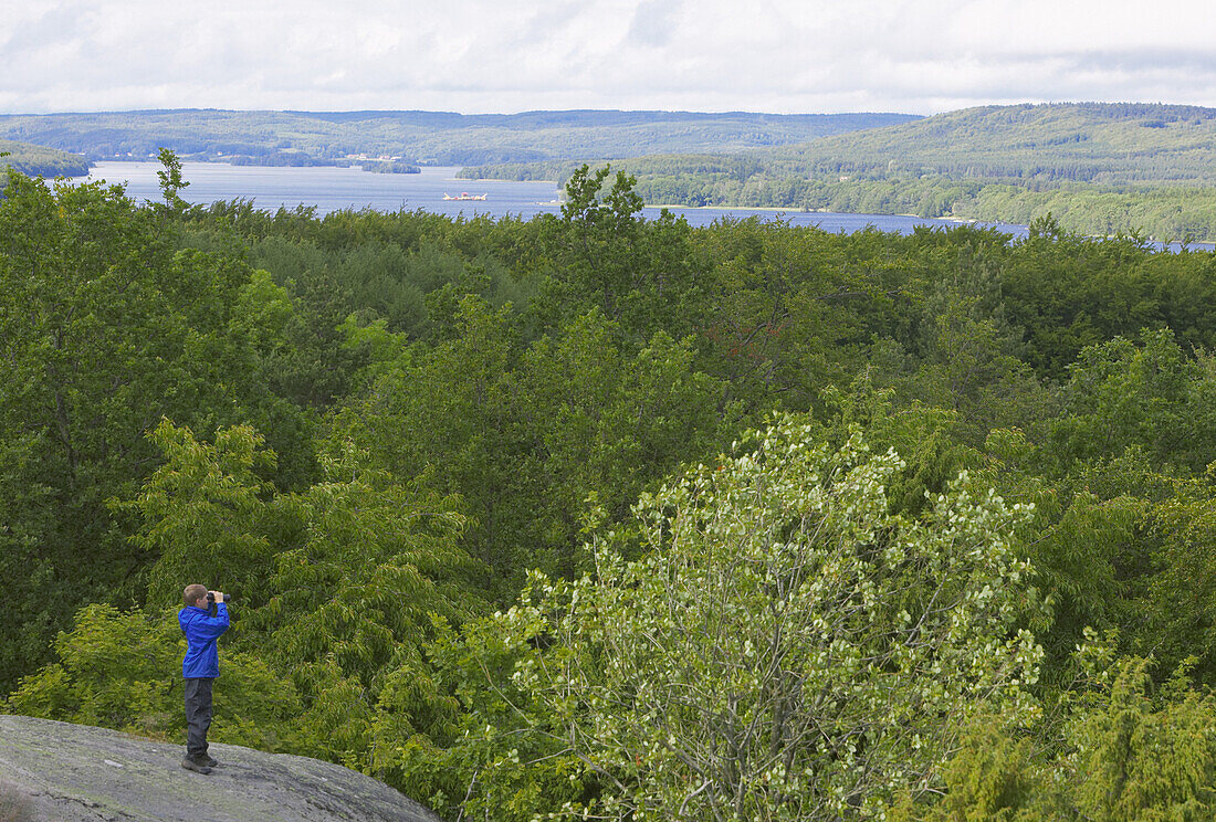 Boy with binoculars on rock