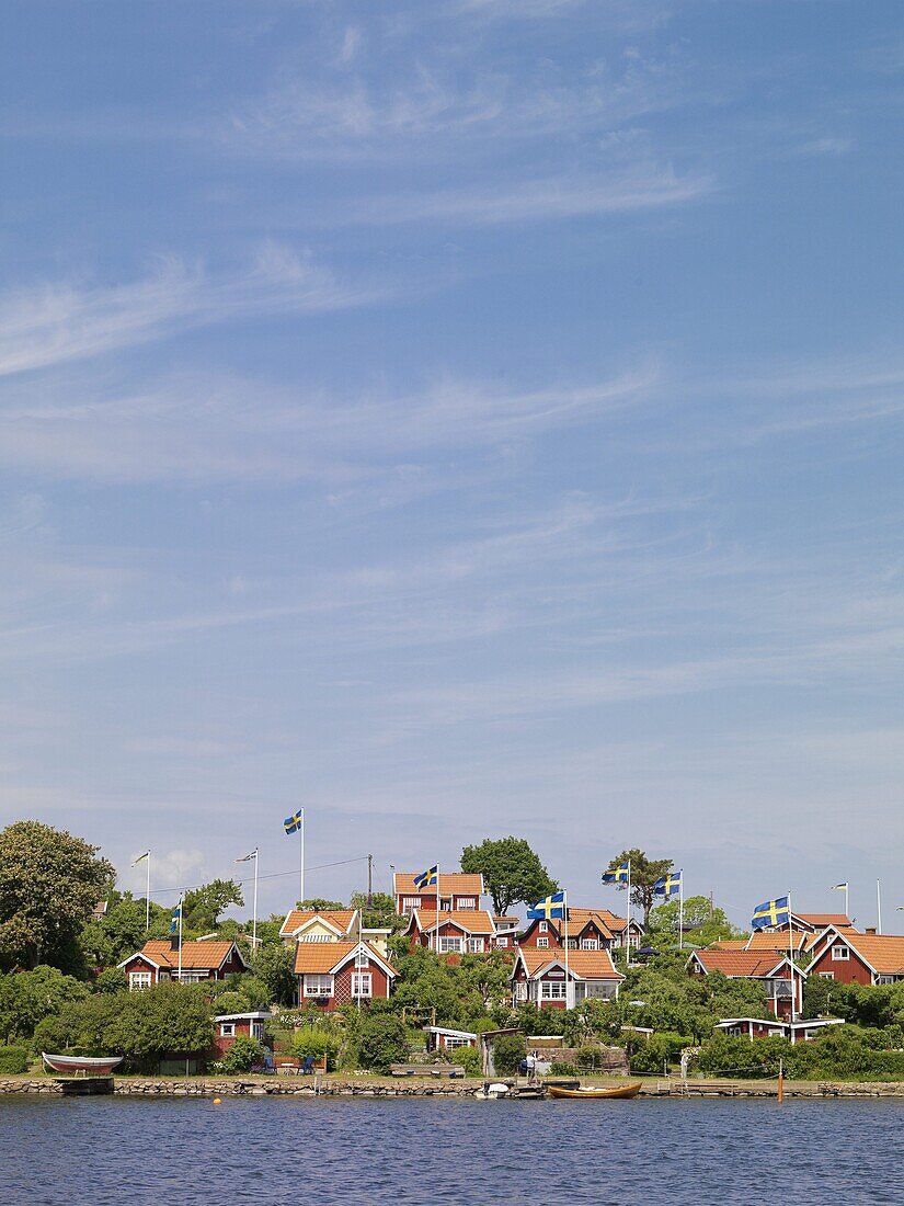 Red houses with Swedish flags in archipelago, Karlskrona, Blekinge, Sweden