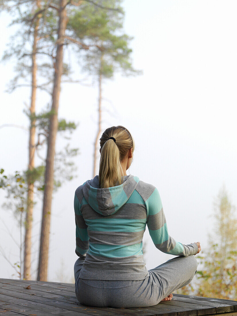 Woman meditates on terrace, Skåne, Sweden