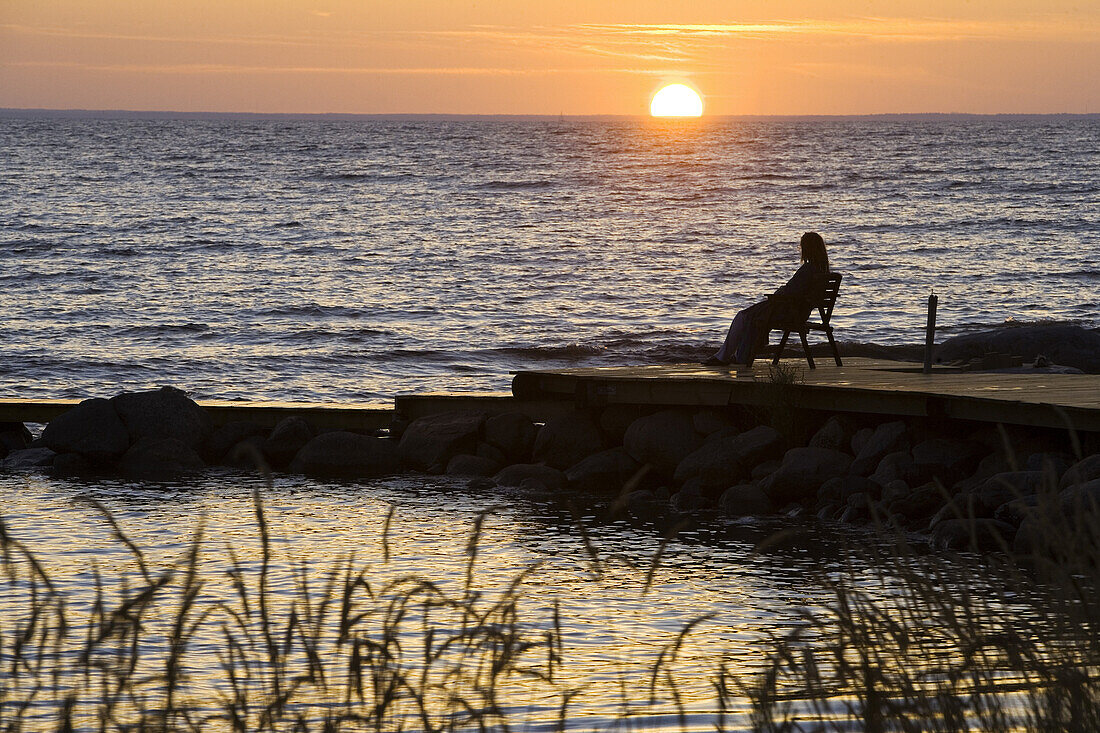 Woman on pier enjoying the sunset
