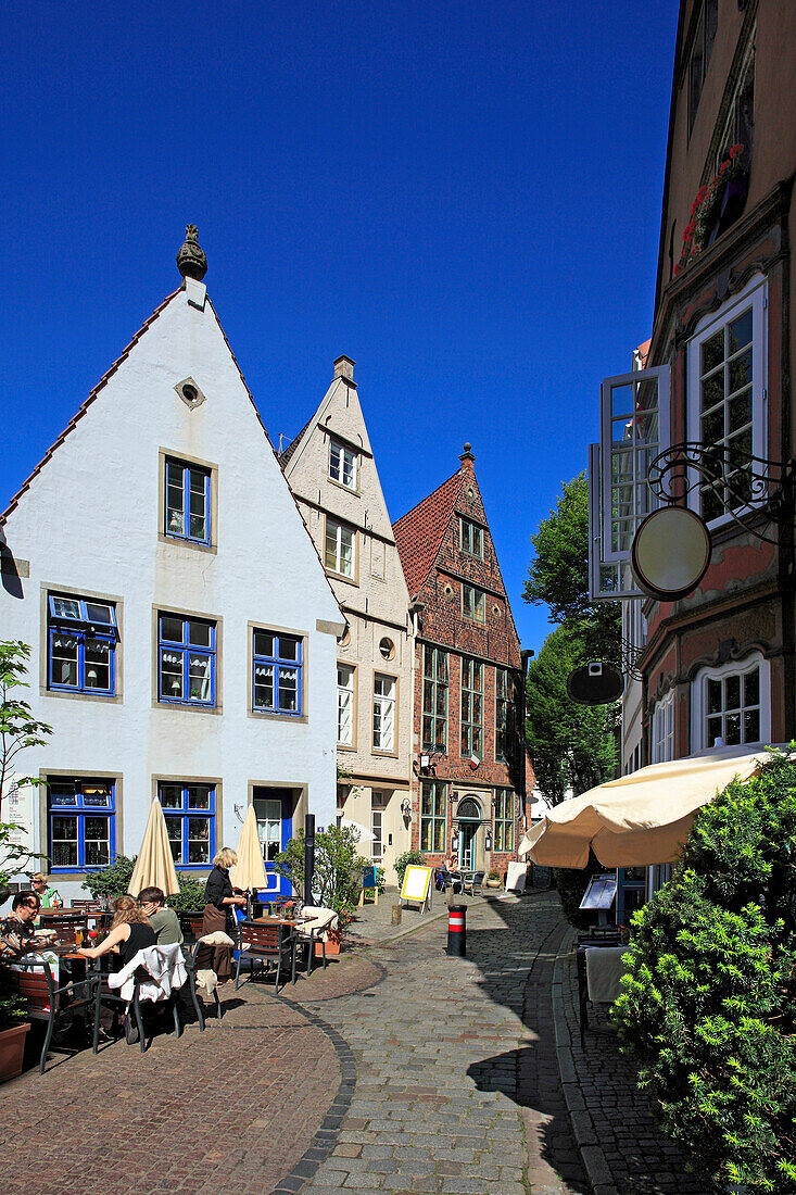 People at street cafe and historical houses at Schnoor quarter, Hanseatic City of Bremen, Germany, Europe