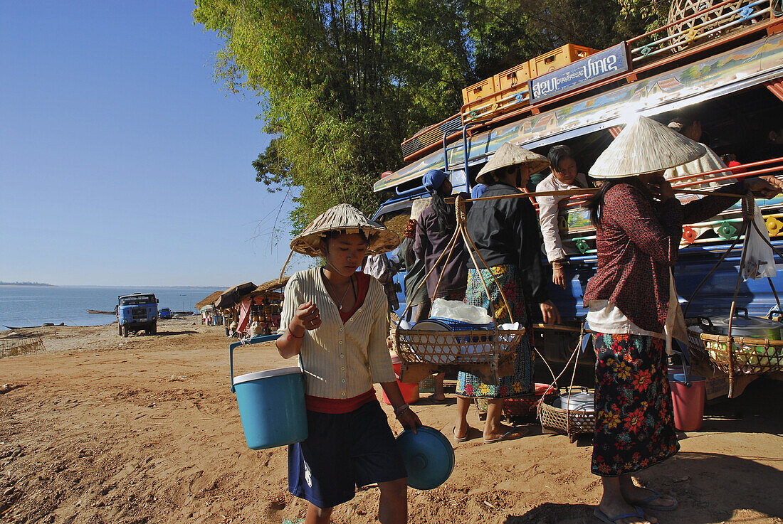 Frauen verkaufen Essen an Buspassagiere, die auf Fähre warten, Champasak im Süden von Laos, Asien