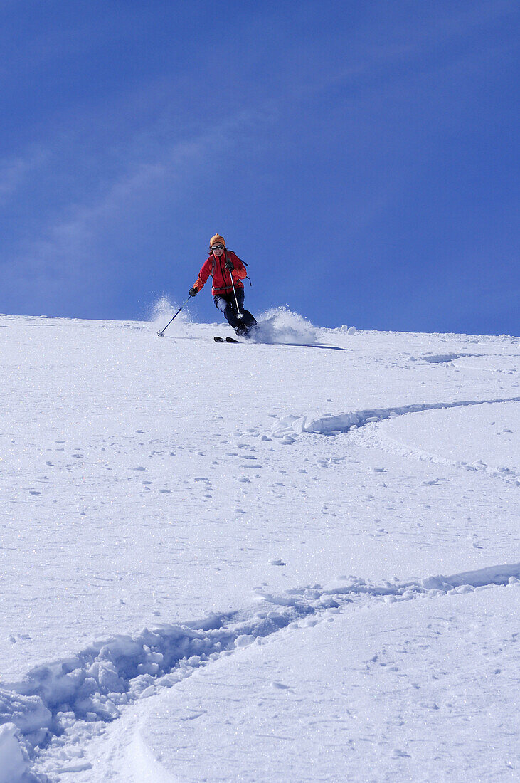 Woman downhill skiing, Granatspitze in background, Granatspitz mountain range, Hohe Tauern, Salzburg, Austria