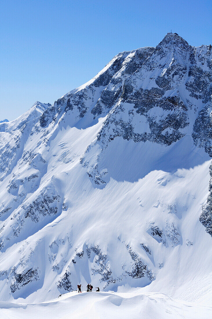 Backcountry skiers beneath Hoher Sonnblick with Zittelhaus hut at the summit, Rauriser Tal valley, Goldberggruppe mountain range, Hohe Tauern mountain range, Salzburg, Austria