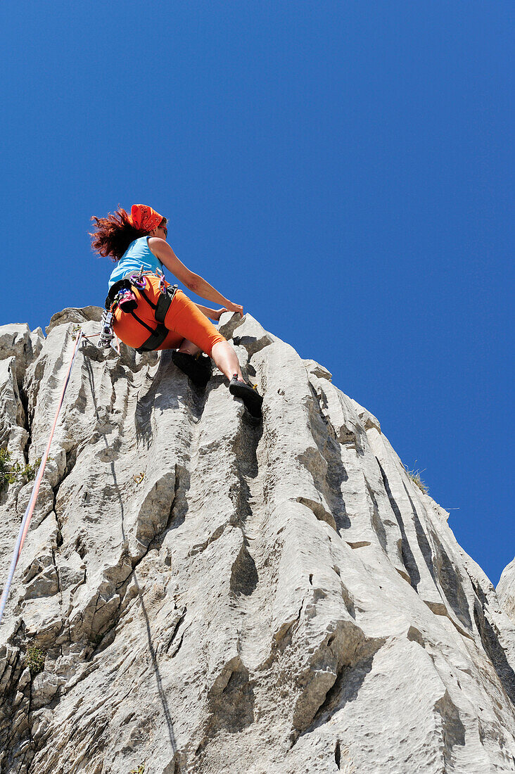 Frau klettert an Felswand, nahe Rifugio Rossi, Pania della Croce, Toskana, Italien