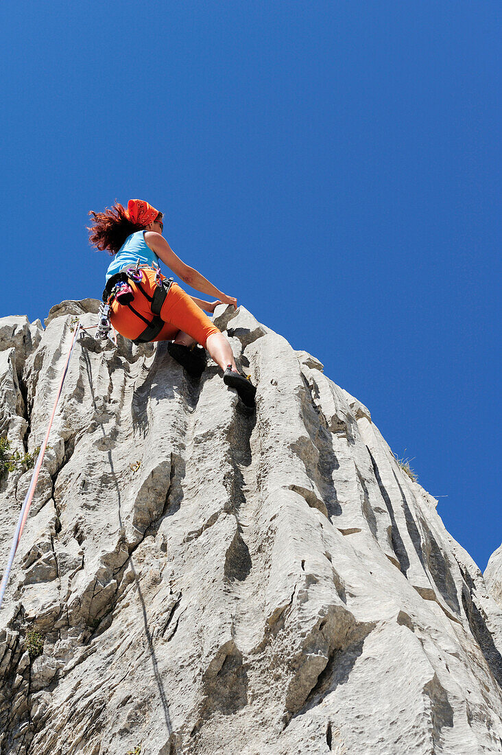 Woman climbing at rock face, near Rifugio Rossi, Pania della Croce, Tuscany, Italy