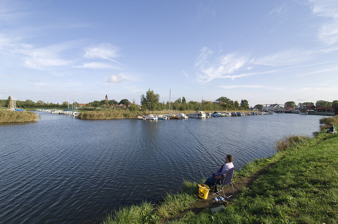 Man fishing along the river, Greifswald, Mecklenburg-Vorpommern, Germany, Europe