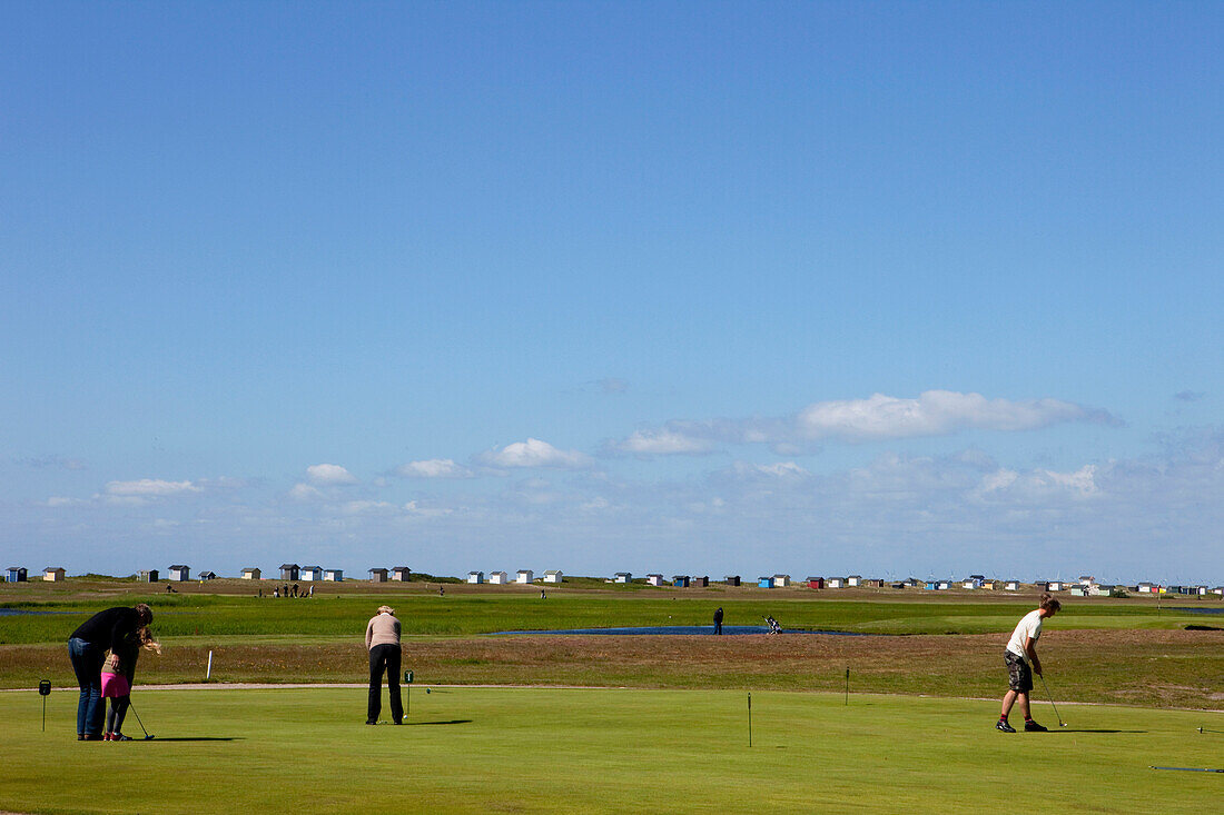 Golfspieler auf dem Golfplatz von Falsterbo mit Strandhäuschen im Hintergrund, Falsterbo, Skanör, Schonen, Südschweden, Schweden
