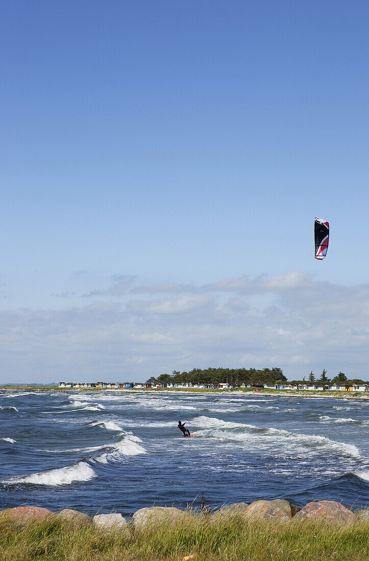 Kite surfer with little beach huts in the background, Skanör, Skane, South Sweden, Sweden