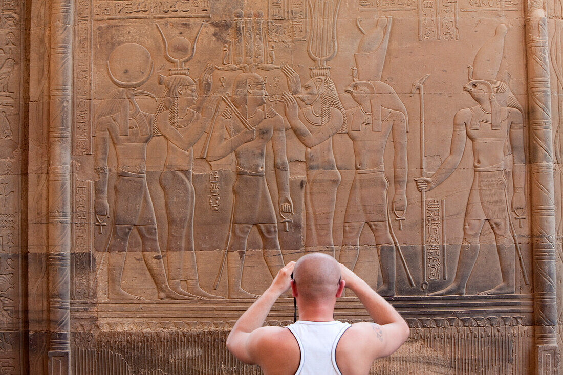 Tourist taking a photograph in front of the Temple of Kom Ombo, Egypt, Africa