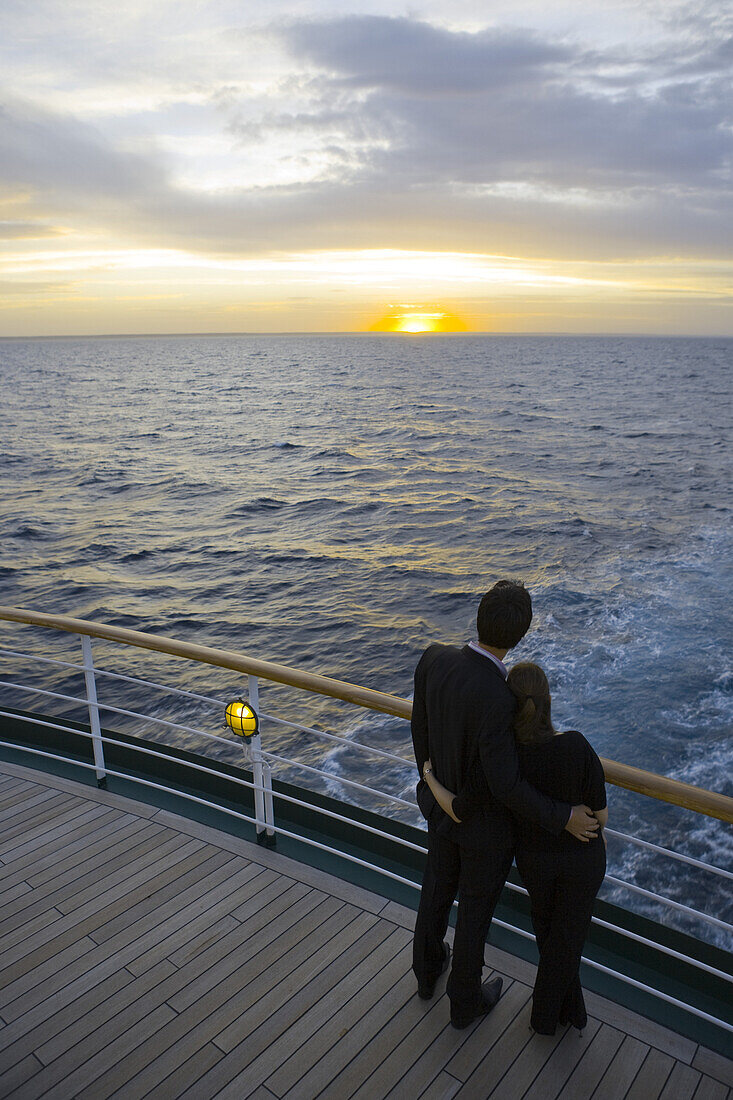 Junges Paar blickt in Sonnenuntergang von an Bord Kreuzfahrtschiff MS Deutschland (Reederei Deilmann), im Südatlantik, Südamerika, Amerika