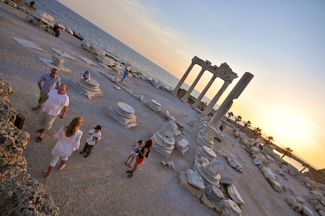 Tourists in the Temple of Appollon and Athena in the evening, Side, south coast, Anatolia, Turkey