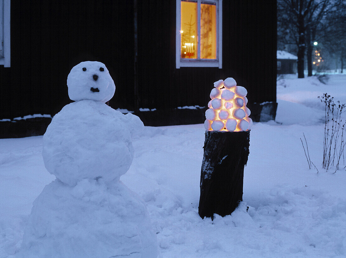 Snowman and snowball lantern in garden