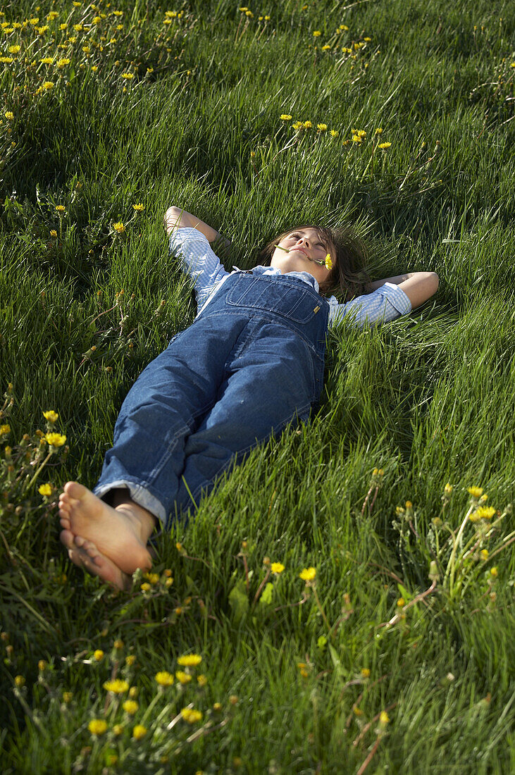 Girl lying on the meadow with dandelions