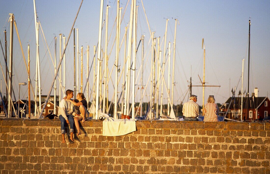 People is sitting on a pier in summertime