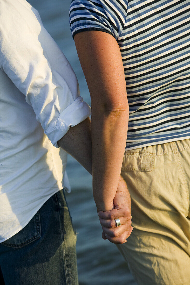 Man and woman wades in the sea, hand in hand