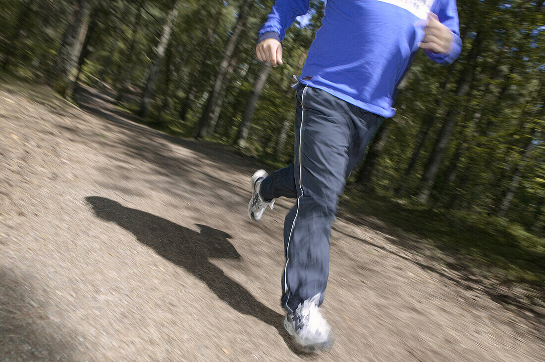 Man runs in Kronoskogen, angelholm, on a fitness path, Skane, Sweden