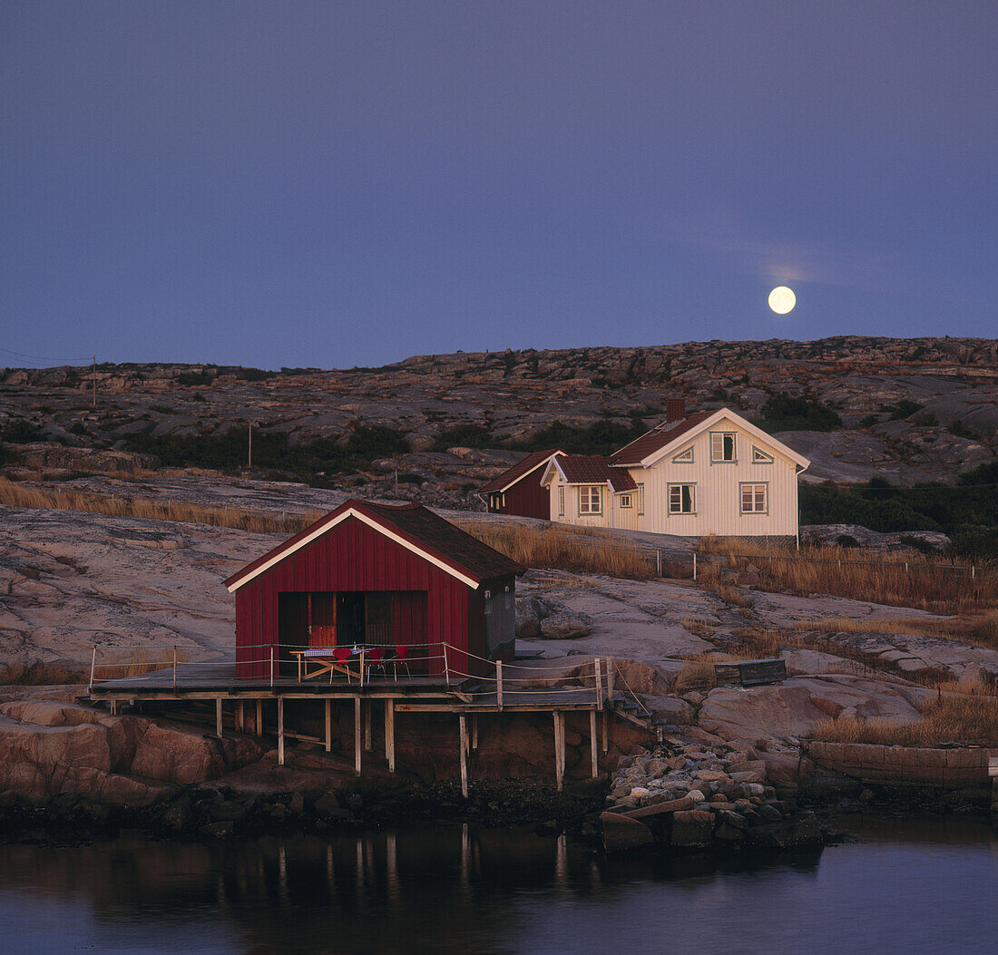 Full moon over house and fishing hut in Bohuslän archipelago, Sweden