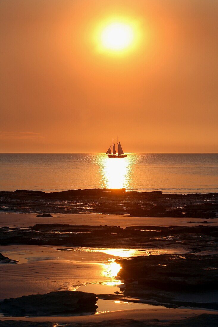 Pearl lugger cruising past Cable beach at sunset  Broome, Western Australia