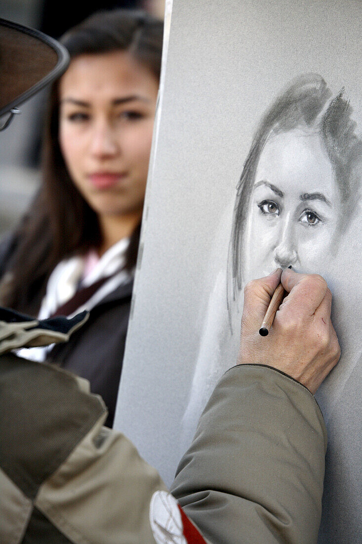 An artist making a sketch for a tourist in Place du Tertre, Paris. France