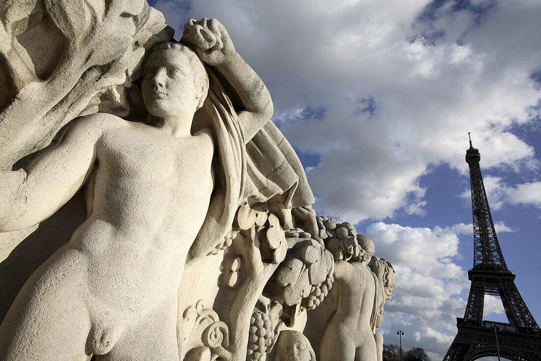 Stone sculptures at the base of the Chaillot pool with Eiffel Tower in background, Paris. France