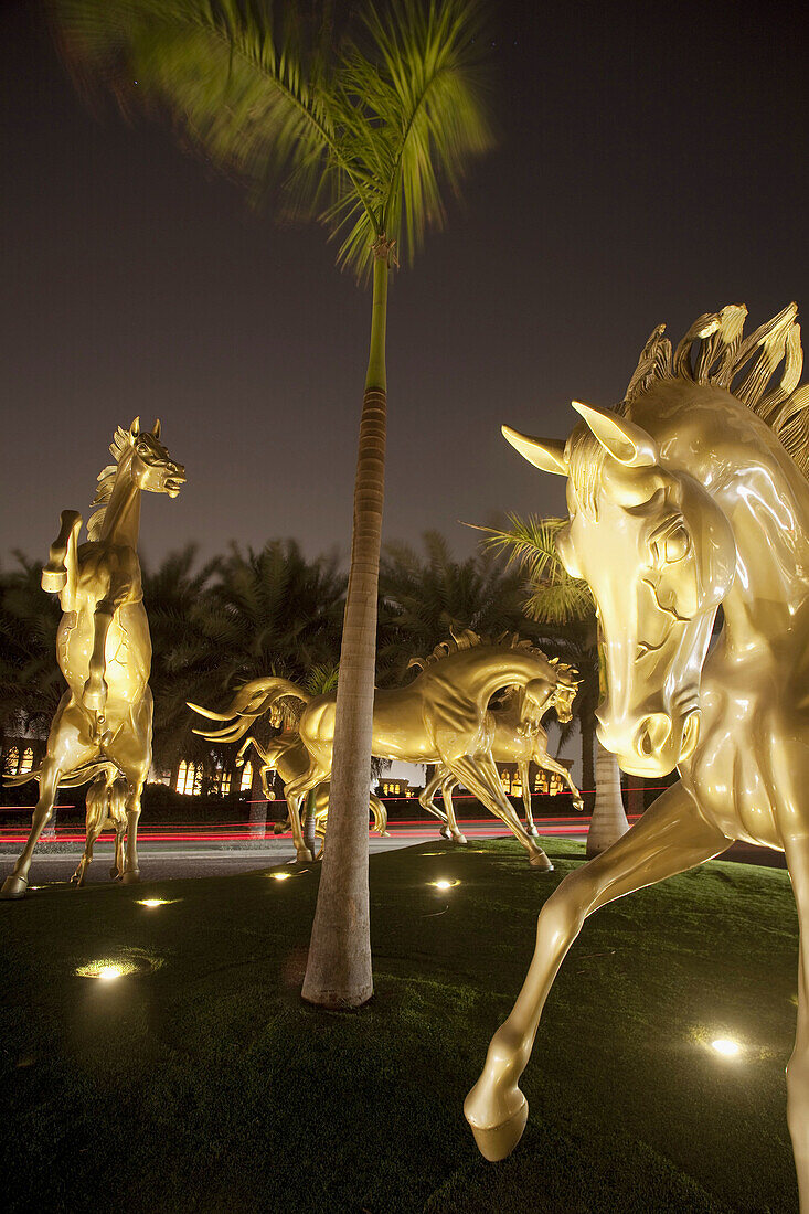 Golden Horses in front of Medinat Jumeirah hotel at night, Dubai, United Arabian Emirates