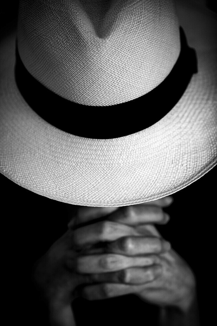A woman is praying under his Panama hat