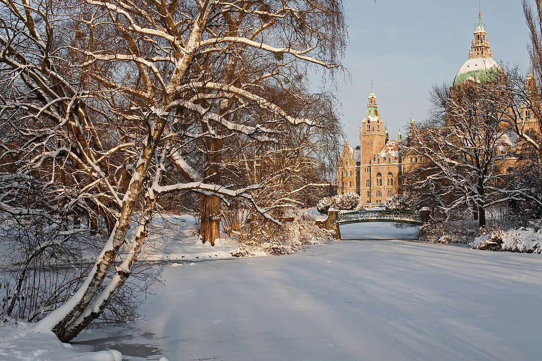 Verschneiter Maschpark, zugefrorener Maschteich mit Brücke, im Hintergrund das Neue Rathaus von Hannover, Hannover, Niedersachsen, Deutschland
