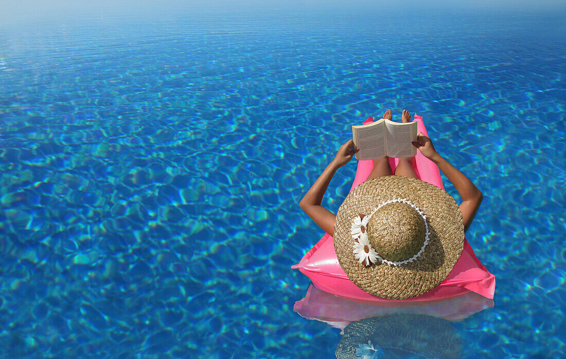 A woman reading a book in an infinity pool, Bohol, Philippines, Asia