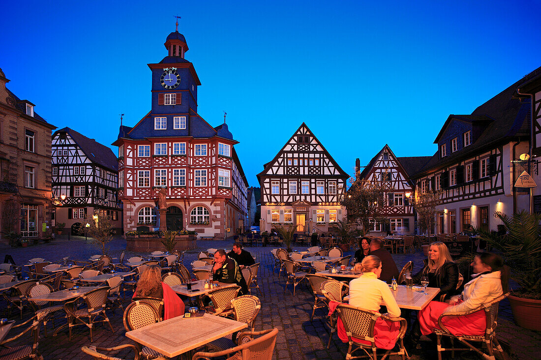 Restaurantgäste am abendlich erleuchteten Marktplatz, Rathaus und Marktbrunnen im Hintergrund Heppenheim, Hessische Bergstraße, Hessen, Deutschland