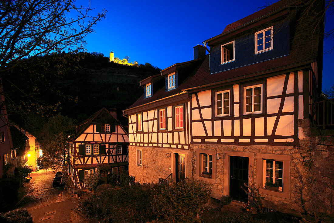 Blick über eine abendlich erleuchtete Gasse mit Fachwerkhäusern zur Starkenburg, Heppenheim, Hessische Bergstraße, Hessen, Deutschland